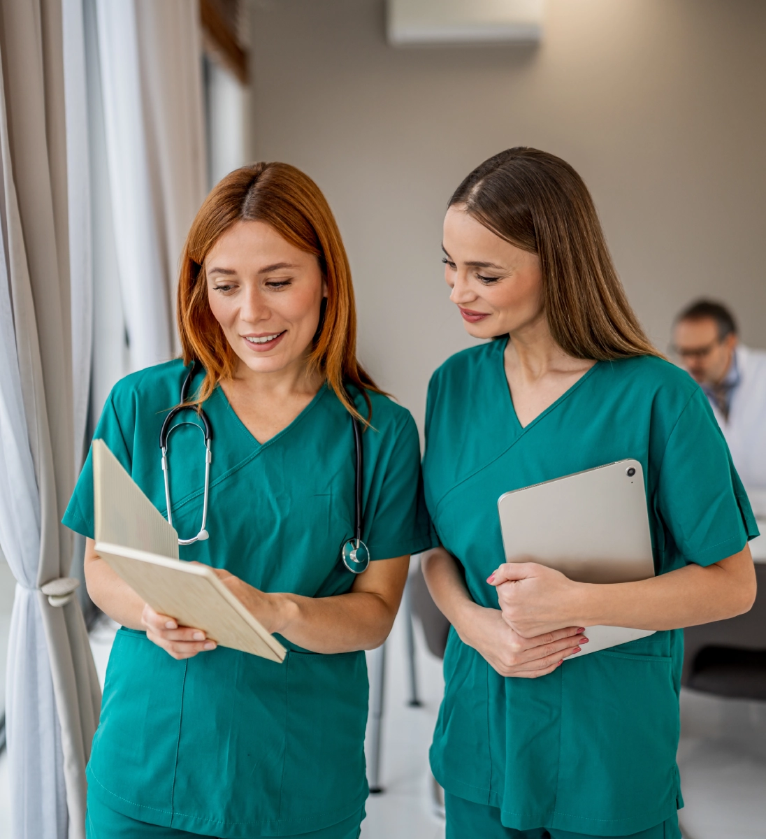 Two nurses discussing patient files together.
