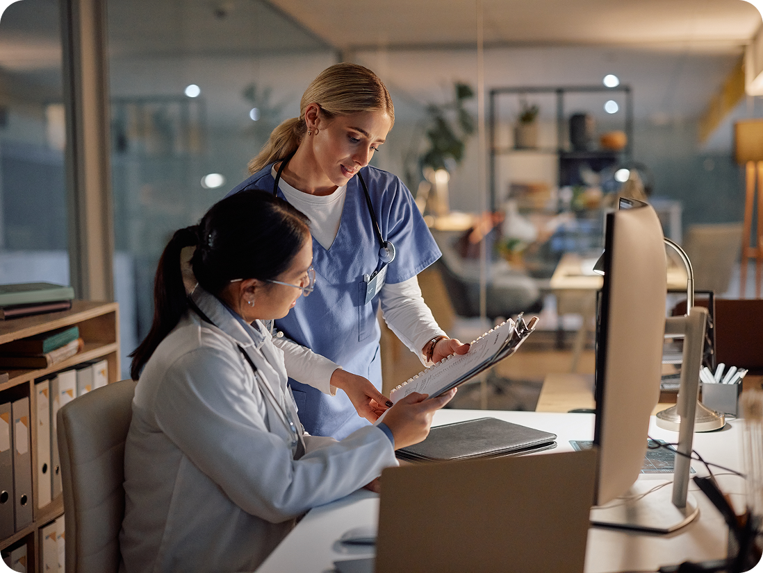 Doctors discussing patient information at a desk.