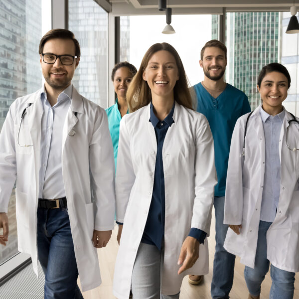 Group of smiling medical professionals walking together.