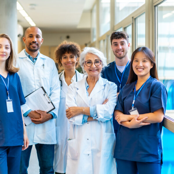 Healthcare professionals posing in a hospital corridor.
