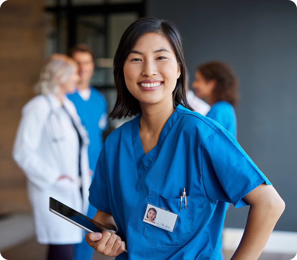 Smiling nurse holding a digital tablet.
