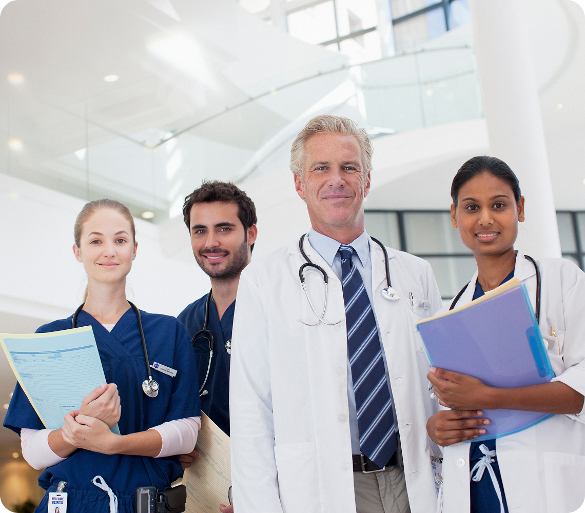 Doctors and nurses standing together, smiling.