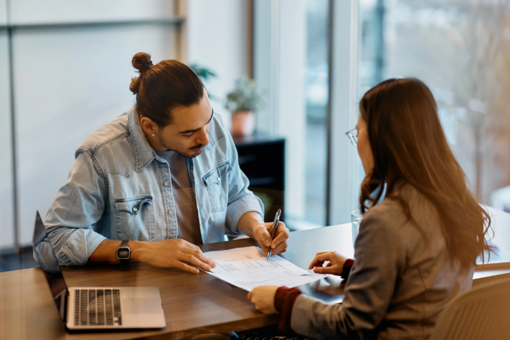 Man and woman reviewing documents at desk.